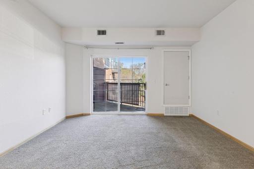 The living room is ready for you to create your home sweet home. A sliding door leads out to the balcony.
