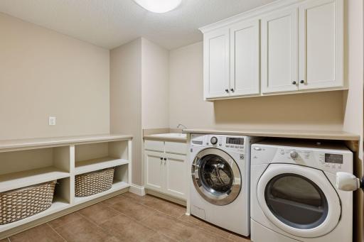 Conveniently, the laundry room is also located on this level for everyday ease. Built-ins, and utility sink