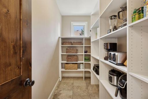 An enormous walk-in pantry with custom shelving keeps everything organized.