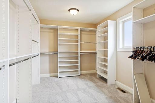 Huge owner's bedroom closet with built-ins and a window allowing natural light.