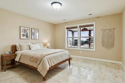 This level also includes a fifth bedroom and a full bath with tiled finishes, offering privacy for overnight guests.