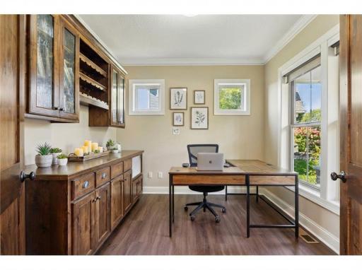 Double doors lead to a main floor office with beautiful built-in cabinetry that provides a private workspace.