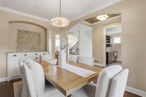 The formal dining room sets the stage for special gatherings with white built-ins and an arched wall inlet.