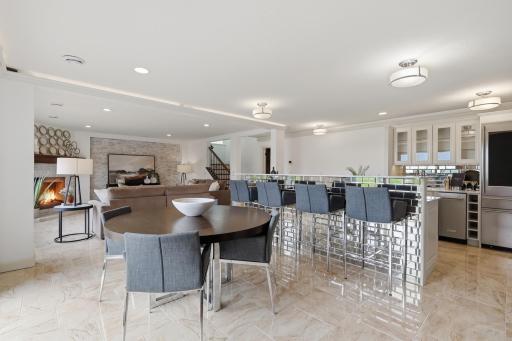 The lower level is designed for entertainment and fun. High ceilings and an open layout create a welcoming space anchored by a striking bar area.