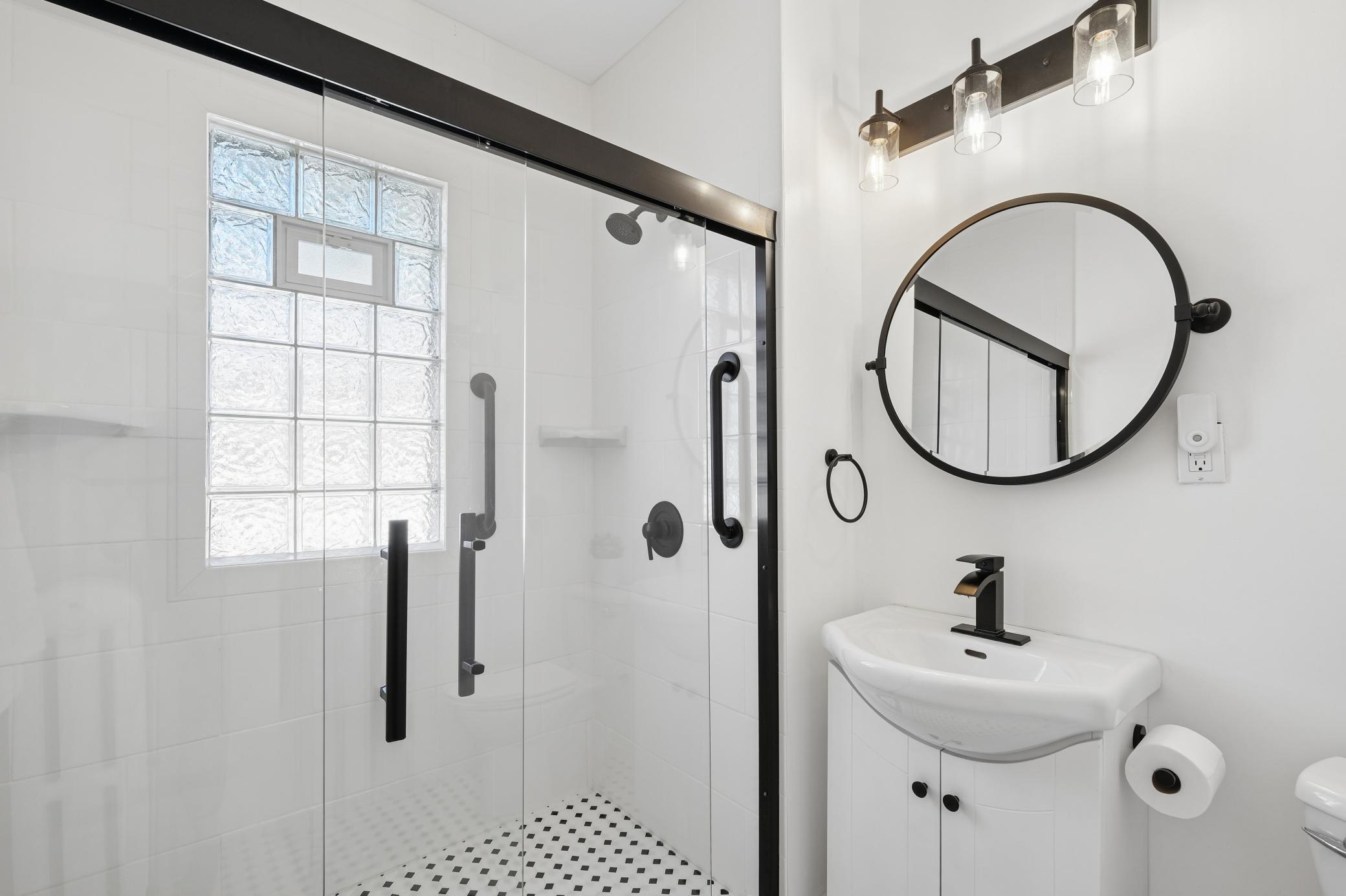 Newly remodeled main level bath with sliding glass shower doors.
