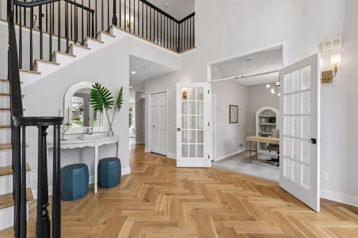 The two-story foyer and grand staircase set the tone, with high ceilings, hardwood floors, and modern updates throughout.