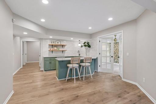Wet bar with modern lighting, open shelving, and full wall tile backsplash.
