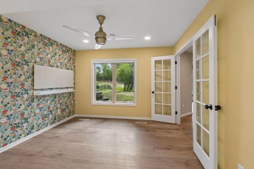Fifth bedroom/flex space downstairs, with french doors and a view of the backyard.