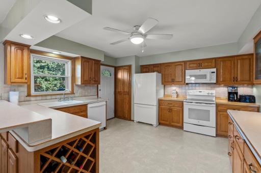 A functional cook-ready space featuring warm wood cabinetry, a white appliance suite, and ample counter space for family meals.