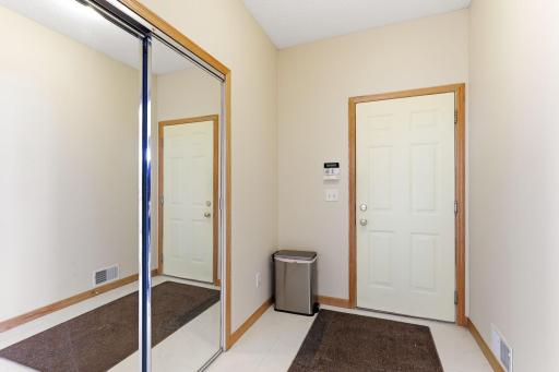 Hallway to 3 stall garage with mirror storage; spacious mudroom area