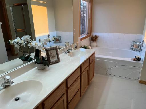 Primary bathroom with dual sink vanity and jetted tub and walk-in shower