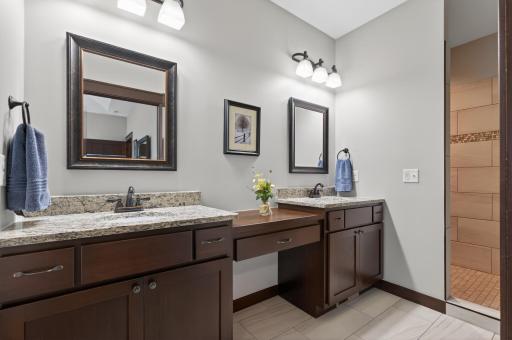 Primary bath with dual vanity counter top, walk-in shower & tile floors