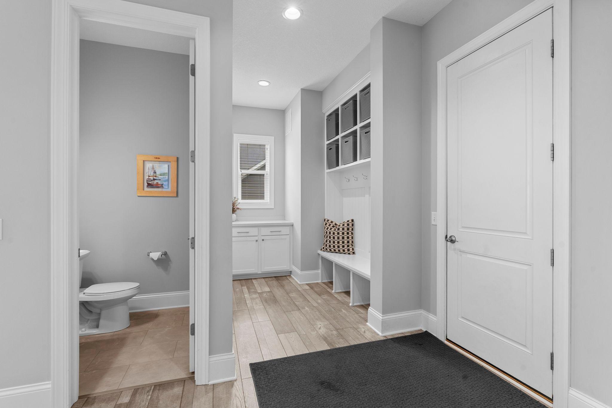 Tucked behind the garage entry into the house, you'll find a powder bath, drop station, built in bench, with hooks and storage, and the primary home office.