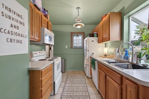 Full kitchen with dishwasher and tiled floors and a kitchen window for daytime views.