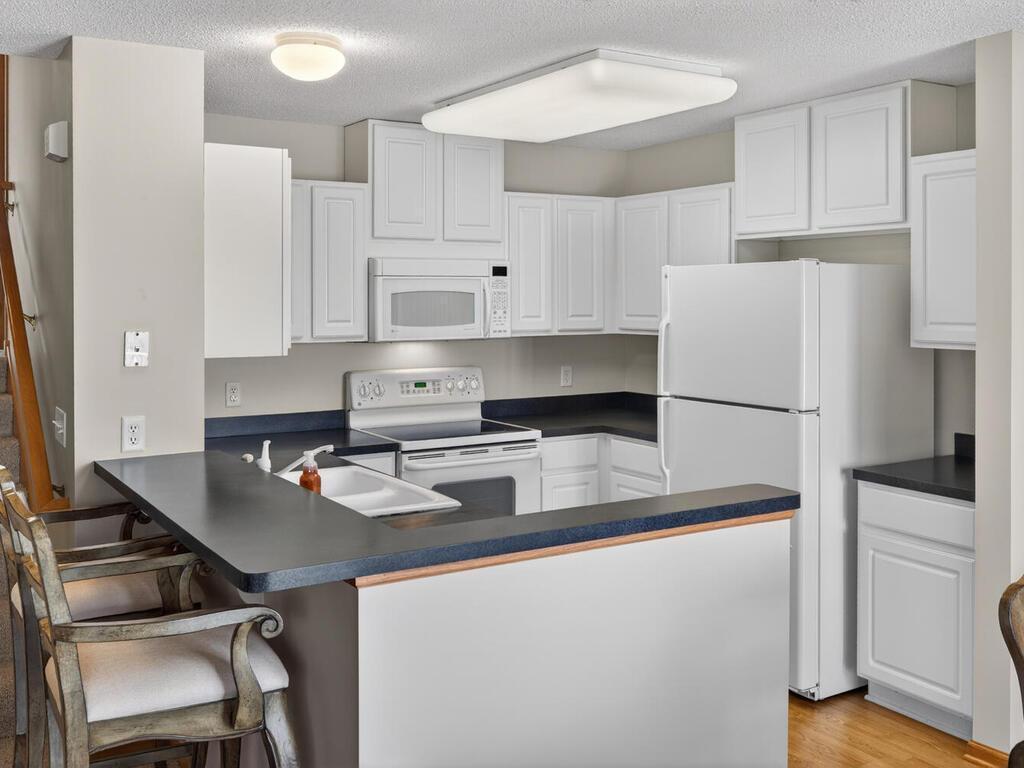 Kitchen with an abundance of cabinets and a cute breakfast bar.