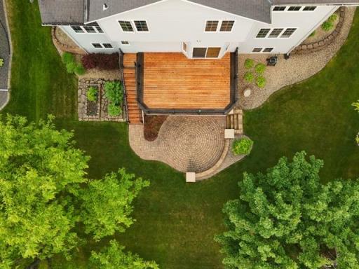 The WALKOUT LOT offers an amazing backyard setting, with a deck, circular paver patio, gardens, and lots of lawn space.