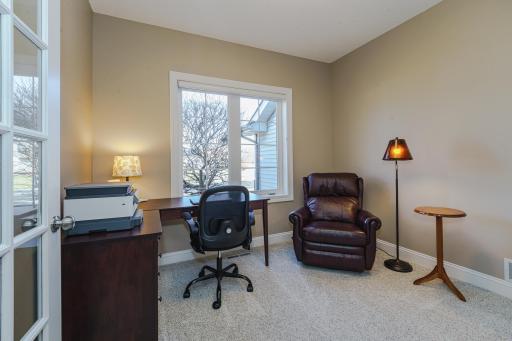 The home office has a gridded glass French door entry and a closet. This space has been freshly painted and overlooks the front of the home.