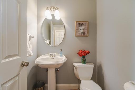 A freshly-painted half bath with hardwood flooring lies off the entry hall.