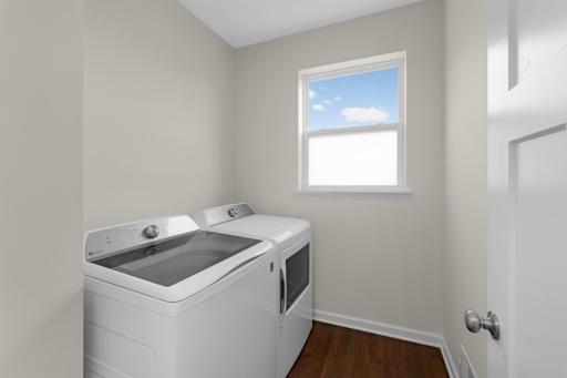 Main-level Laundry Room with window for natural light and additional storage space.