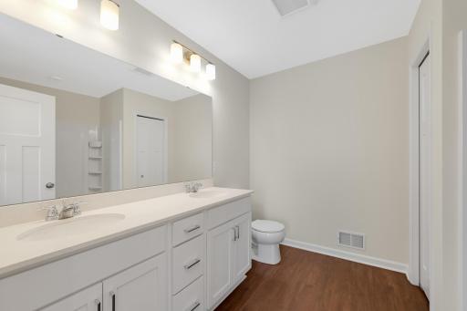 Spacious Primary Bath featuring a double-sink quartz vanity, walk-in shower, ample cabinet storage, and a large mirror to make busy mornings a breeze.