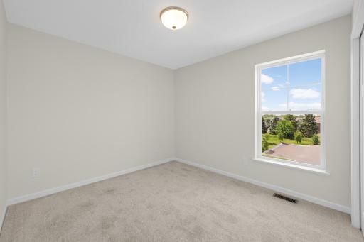 Secondary bedroom with abundant natural light and views of the neighborhood.