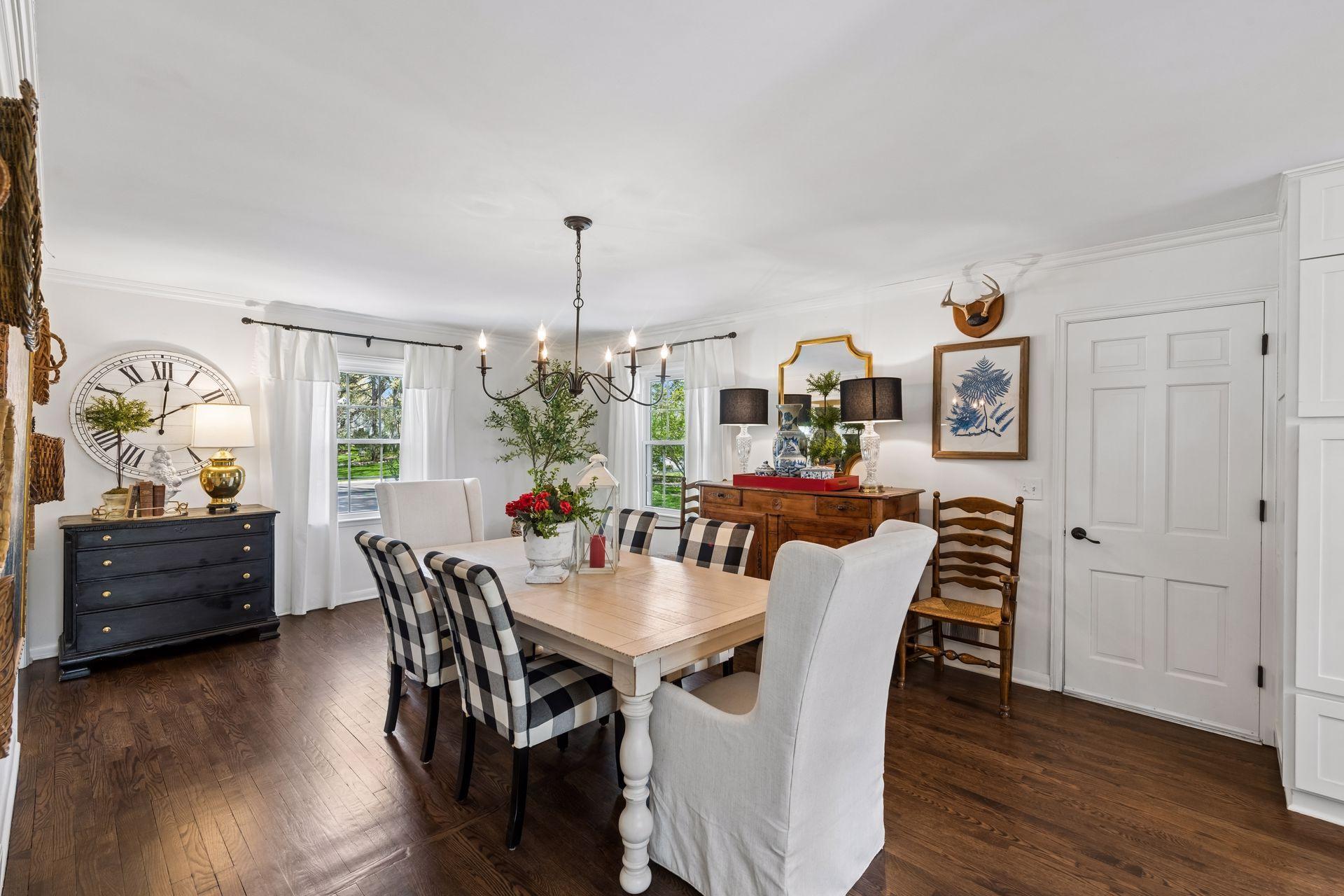 The stylish dining room features updated lighting fixtures and refinished hardwood floors