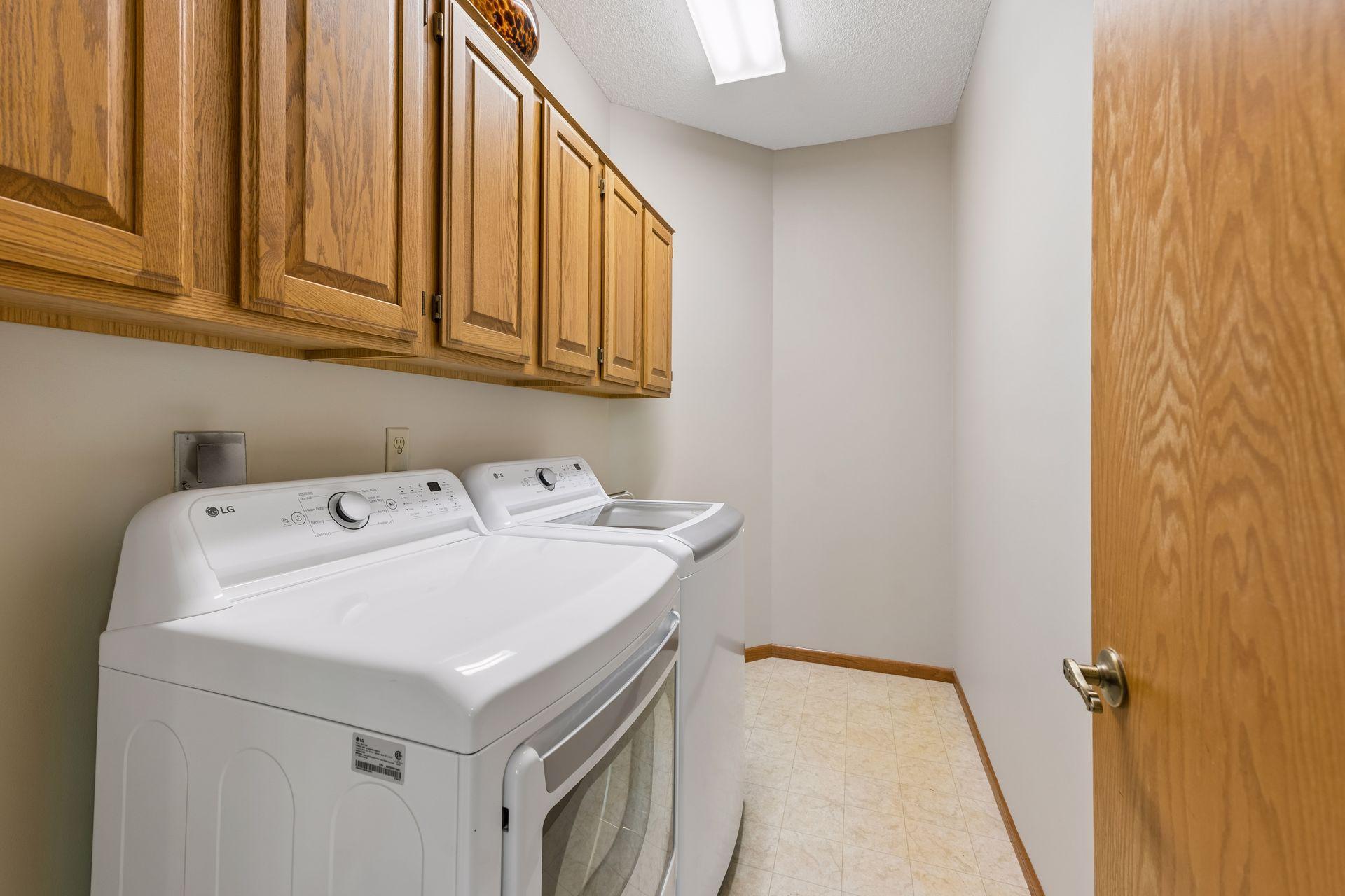 The laundry room has built-in cabinets and a utility sink.