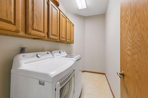 The laundry room has built-in cabinets and a utility sink.