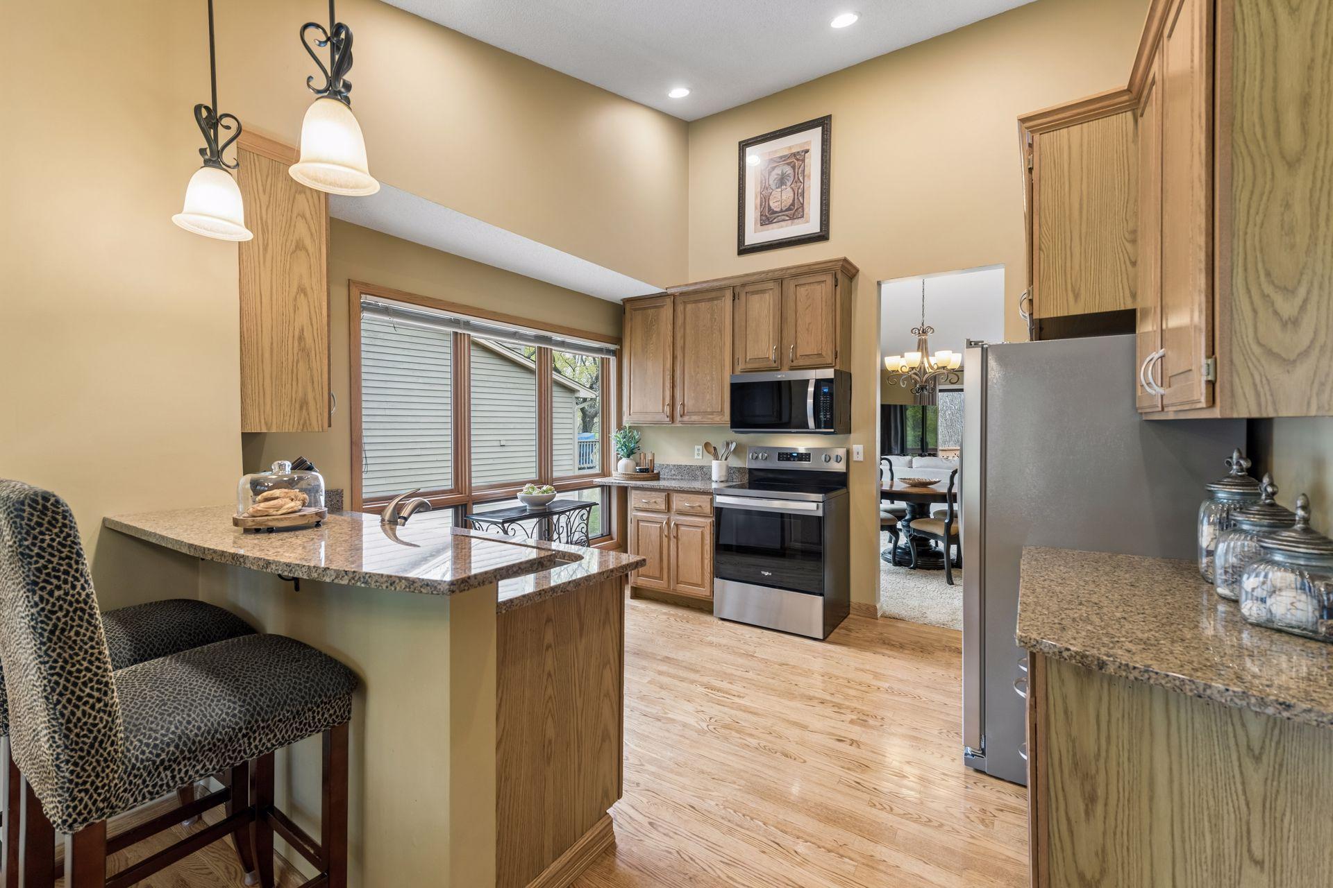 The updated kitchen features new stainless steel appliances, granite countertops, ample cabinetry, and a convenient breakfast bar.