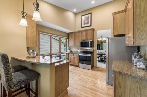 The updated kitchen features new stainless steel appliances, granite countertops, ample cabinetry, and a convenient breakfast bar.