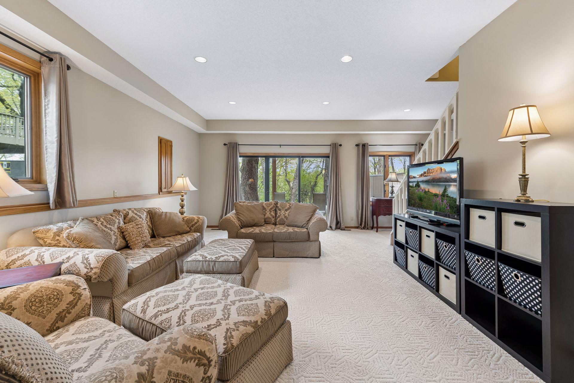 Walkout lower-level family room with extra-high ceilings, offering generous additional living space. Newer side window and access to the patio and backyard.