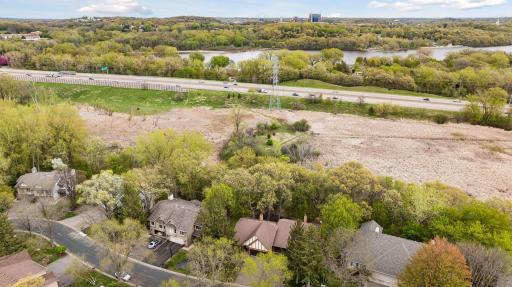 This aerial view shows that the dense tree line extends beyond the home. You can even see the walking trail in the wetlands.