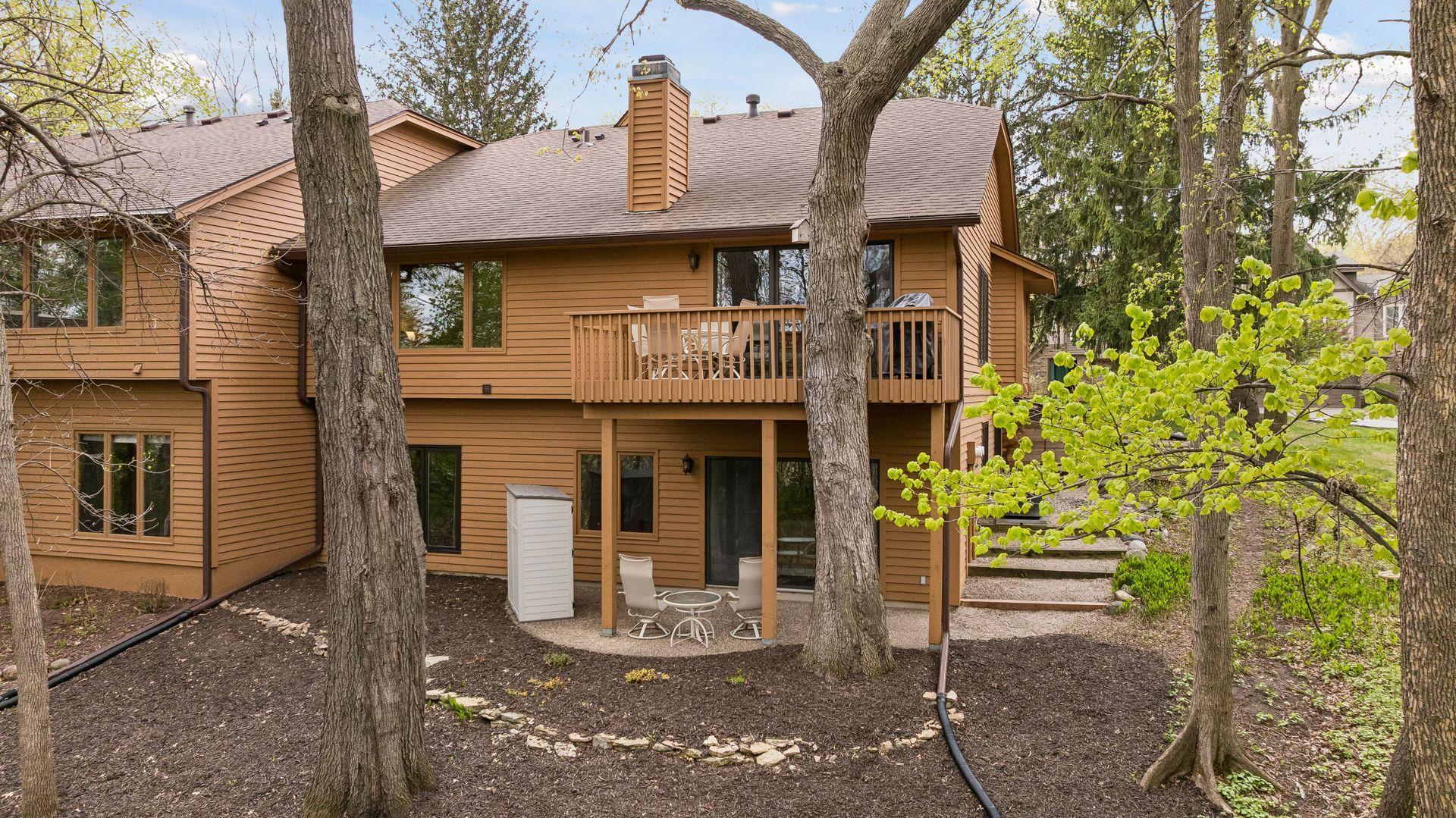 The lower-level patio space is tucked under the deck and provides for additional outdoor seating. The tiered steps along the side of the home make it easy to access the backyard from the front.