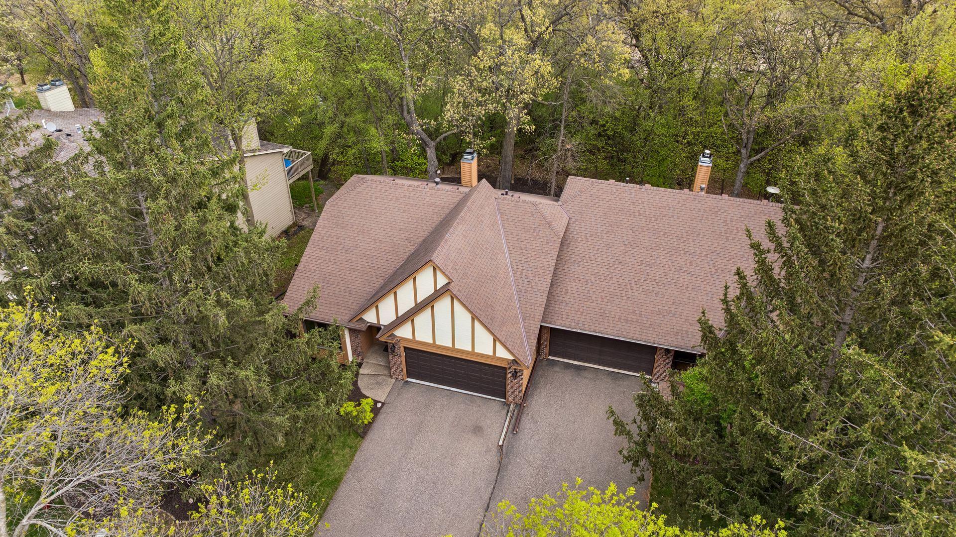 This aerial view shows that the home is surrounded by mature trees.