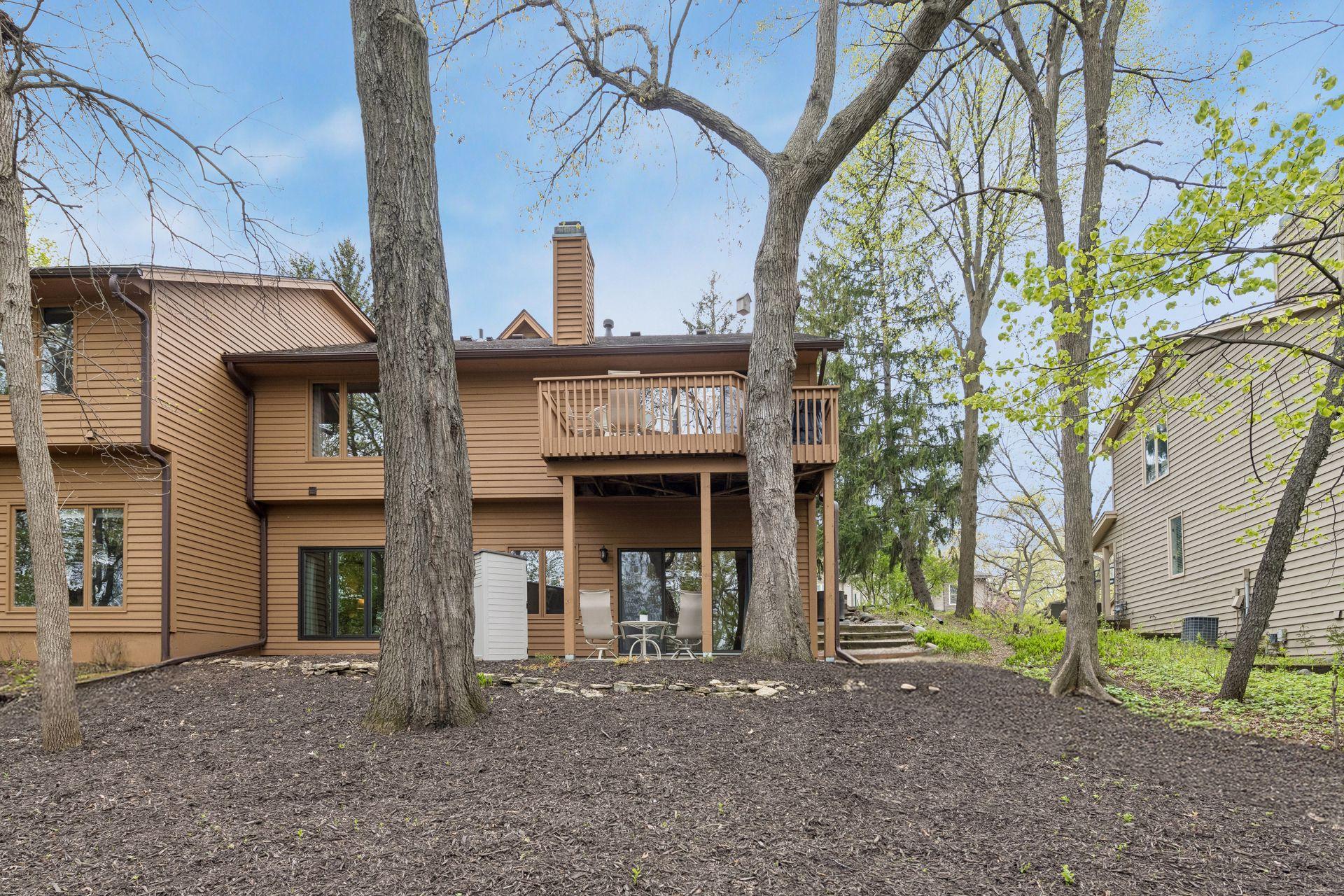 A centered view of the back of the home, backyard, deck, and patio.