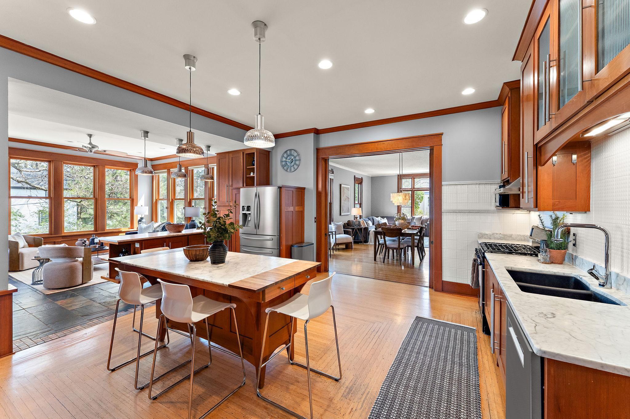 The kitchen flows into the sunroom, which offers heated floors and a gas fireplace