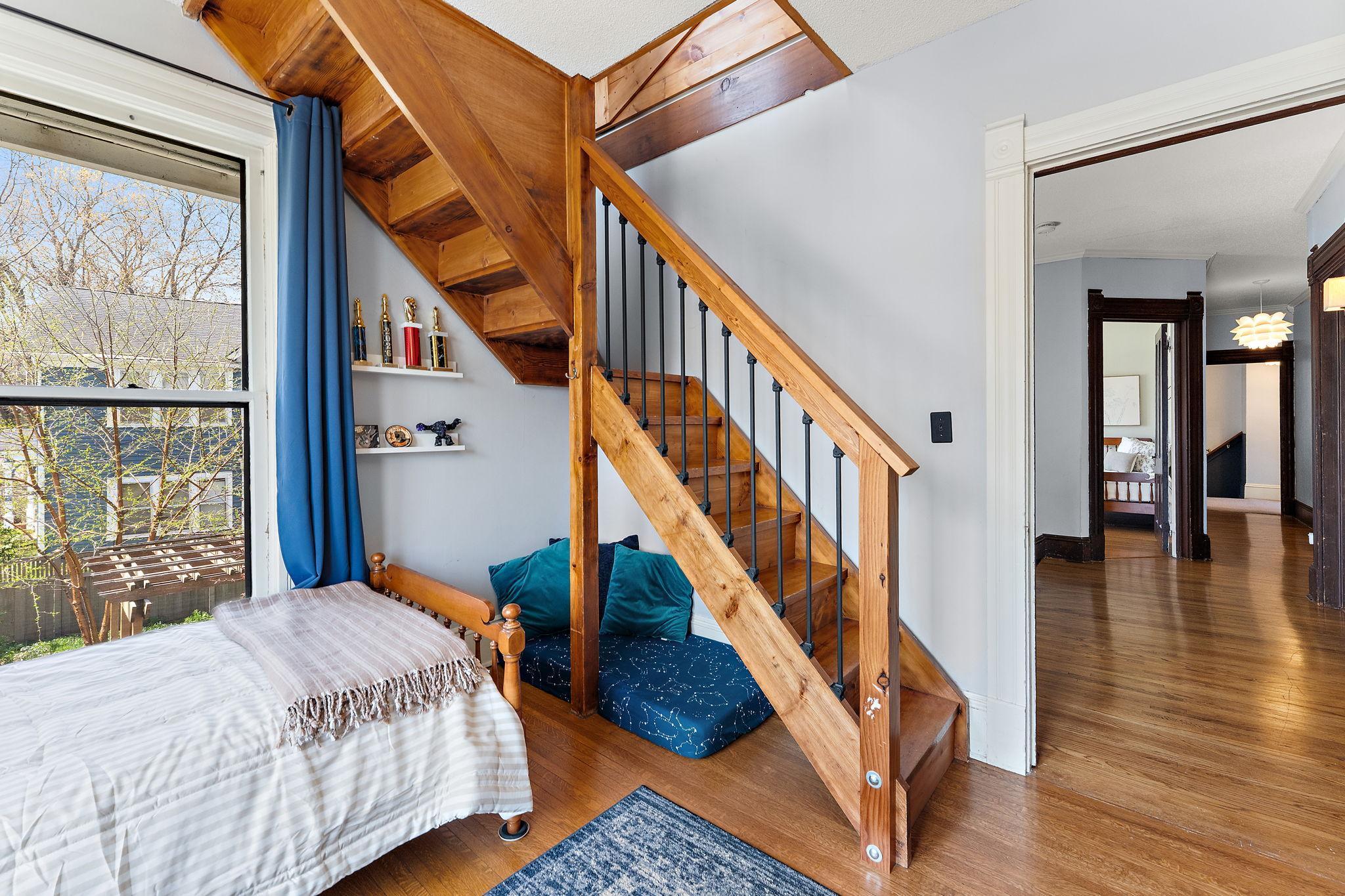This bedroom has an updated stairway & railing combo leading to a delightful tower