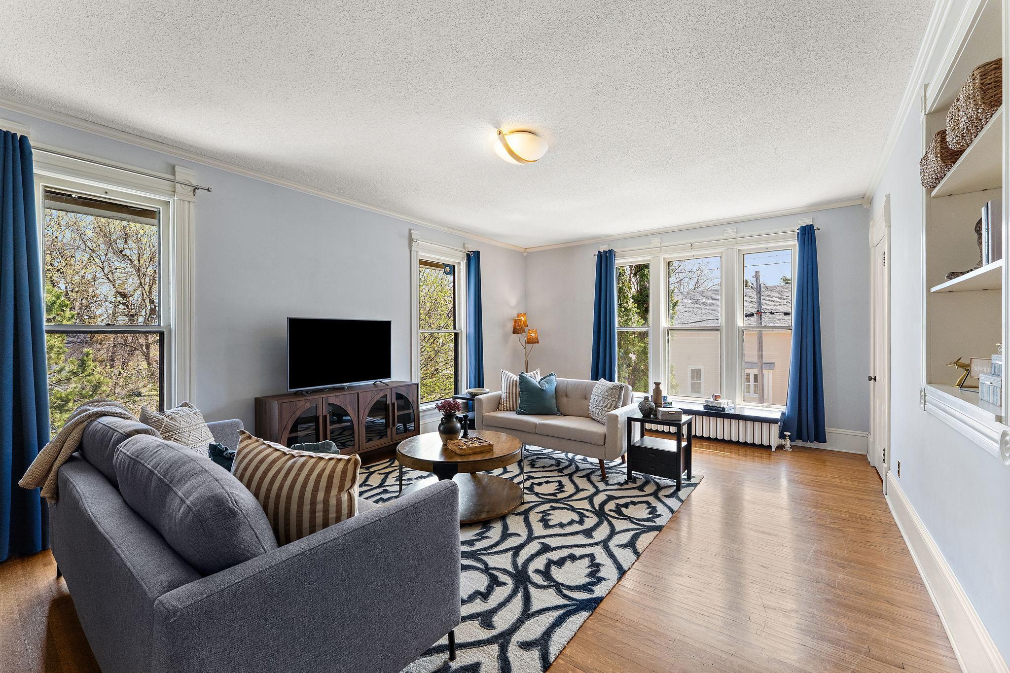 Two huge closets, built in shelving and tall windows in this large bedroom or family room at the top of the stairs
