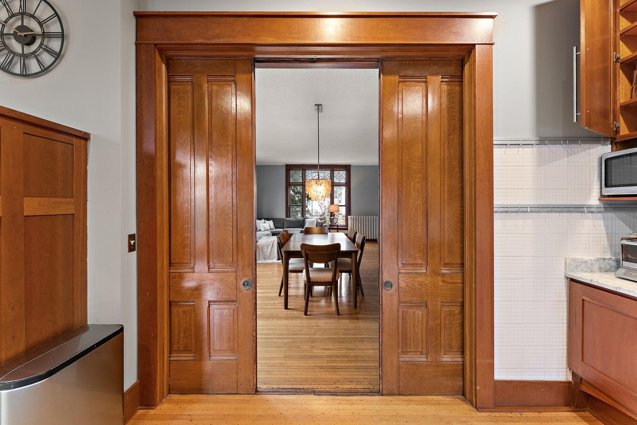 Functional pocket doors with original details and trim between the kitchen and dining room