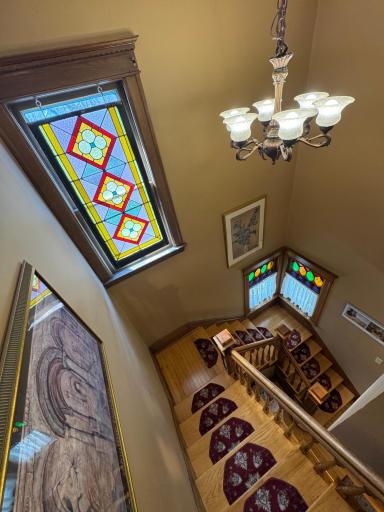 Stunning diamond-pattern quarry leaded glass windows with red and green cathedral accents, a defining characteristic of Queen Anne design