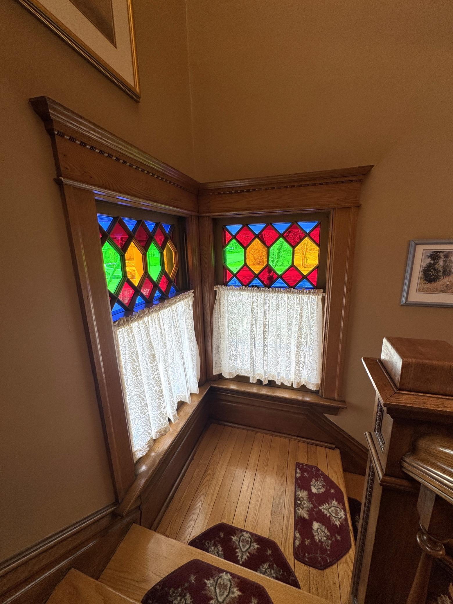 Diamond-pattern quarry glass medallion windows with red, green & yellow cathedral accents