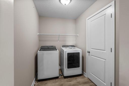 Upstairs laundry room includes a Samsung washer and dryer, plus shelving.