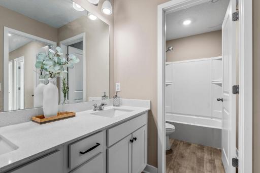 The bedrooms are just steps from a shared full bathroom with dual sinks, a separate water closet, and a tub/shower combination.