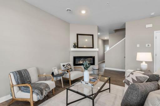 The spacious living room offers a cozy electric fireplace, and recessed lighting.
