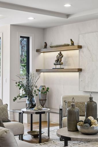 Main floor great room lighted custom shelves.