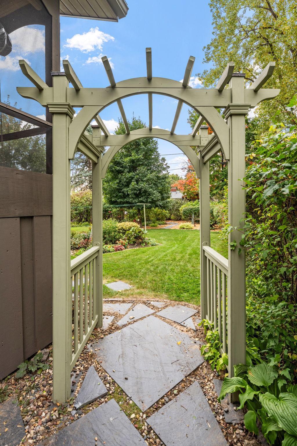 Archway and pavers welcome you to lovely backyard