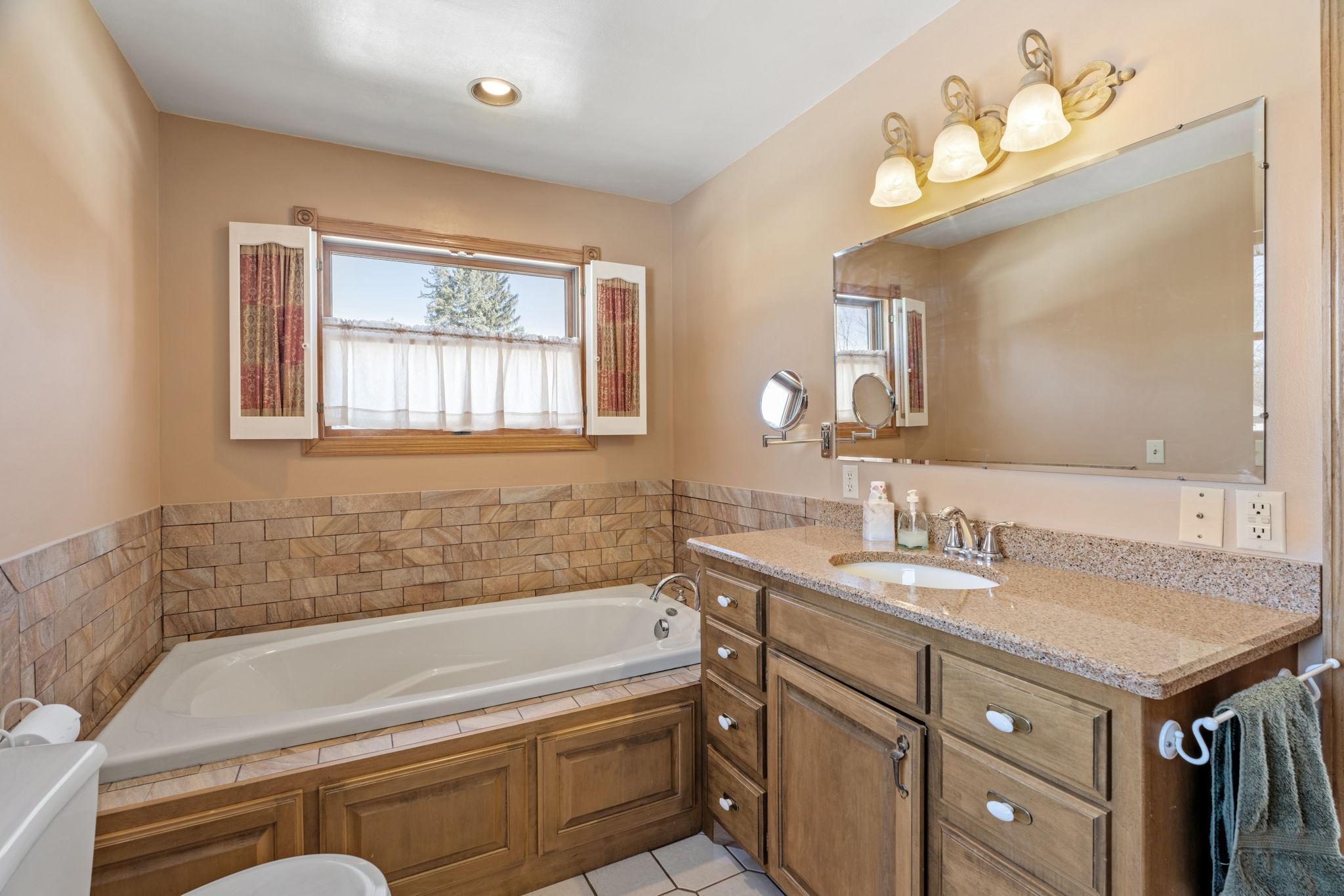 Enjoy a relaxing jacuzzi bath in lovely tiled & granite bath