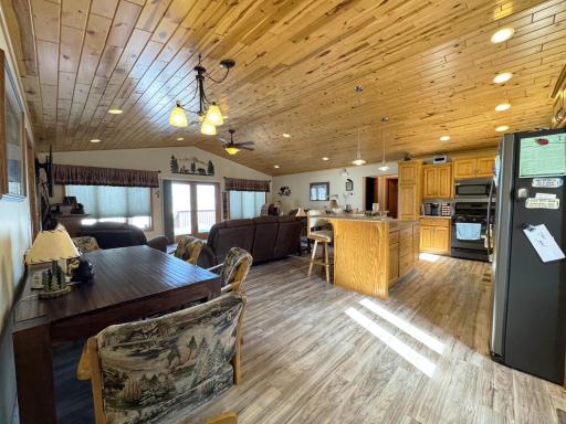 A shot of the great room from the entry door area, featuring the kitchen. dining room, and living room beyond.
