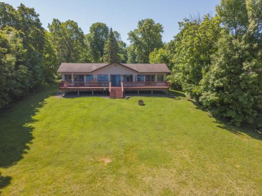 Another angle of the home's exterior with the lakeshore at your back...tucked in amidst the treed yard with the gentlest of slopes to the lake will bring you to the crystal clear waters of MilleLacs!