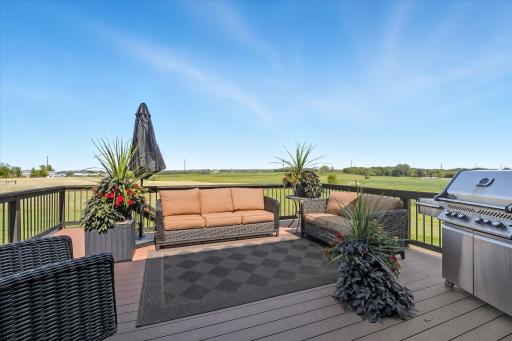 Spacious back deck with seating, grill area with gas line already installed, and sweeping views of the surrounding countryside, perfect for entertaining.